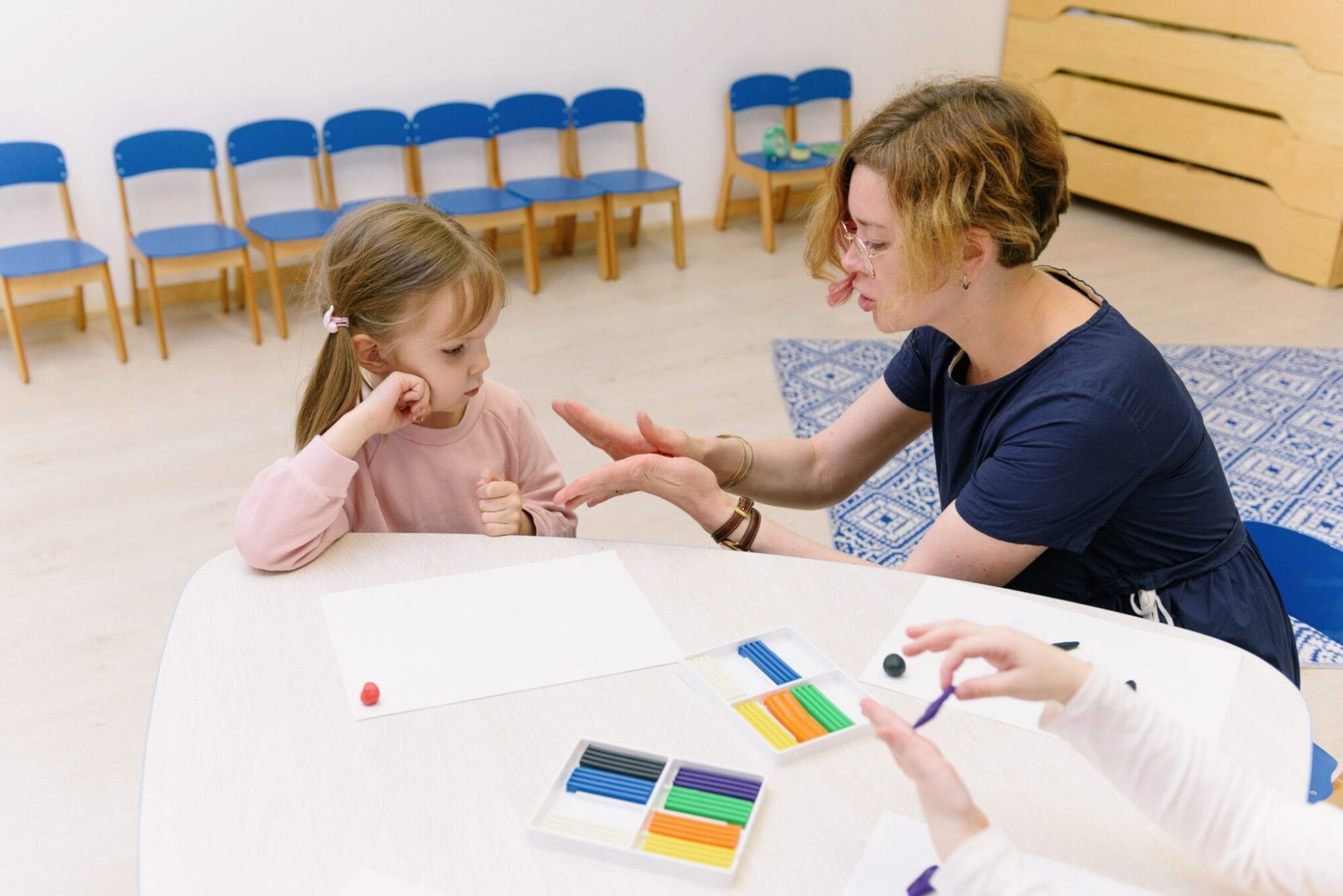 Speech therapist working with a child at a table